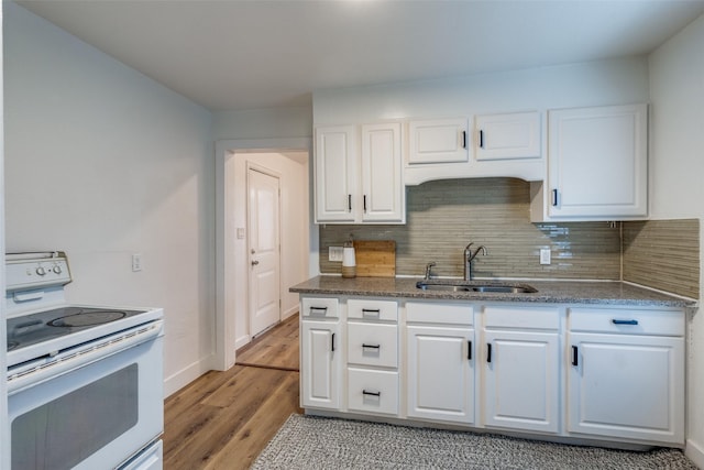 kitchen featuring white range with electric cooktop, white cabinets, sink, decorative backsplash, and light hardwood / wood-style floors