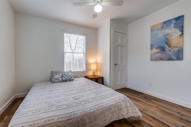 bedroom with dark hardwood / wood-style flooring and ceiling fan