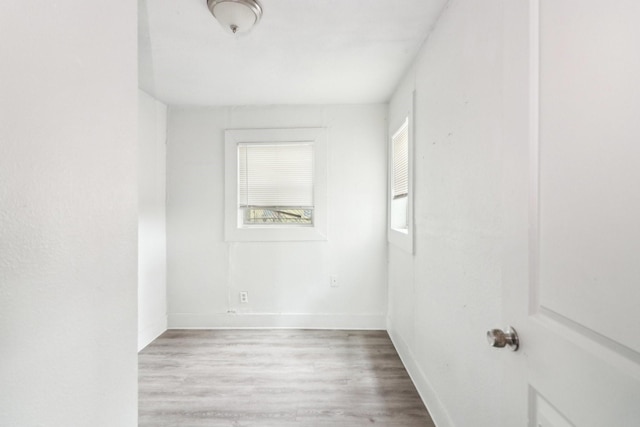 empty room featuring light wood finished floors and baseboards