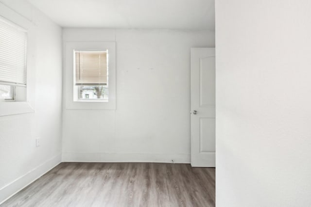 spare room with light wood-type flooring and baseboards