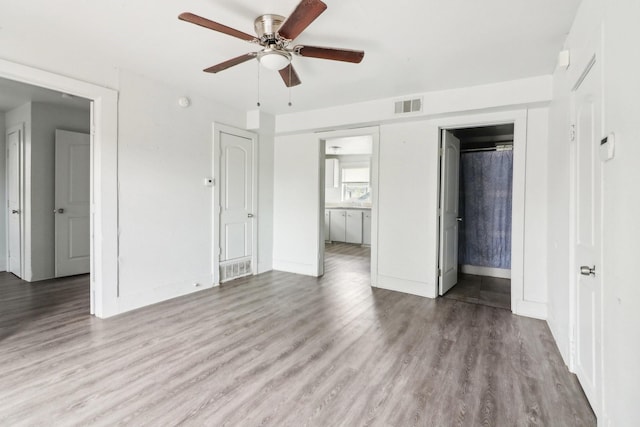 unfurnished bedroom with light wood finished floors, a ceiling fan, visible vents, and baseboards