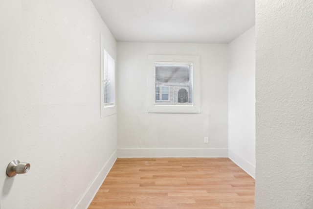 empty room with baseboards and light wood finished floors