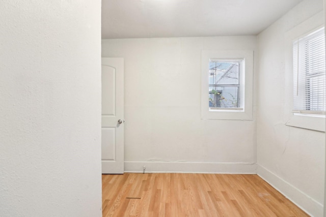 unfurnished room with baseboards and wood finished floors