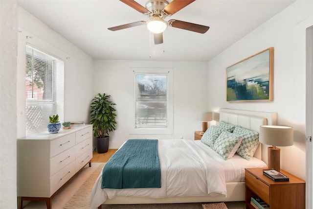 bedroom with light wood finished floors and a ceiling fan