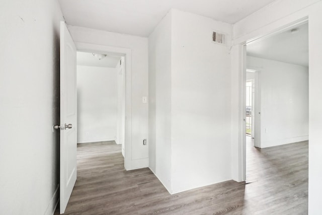 corridor with wood finished floors and visible vents