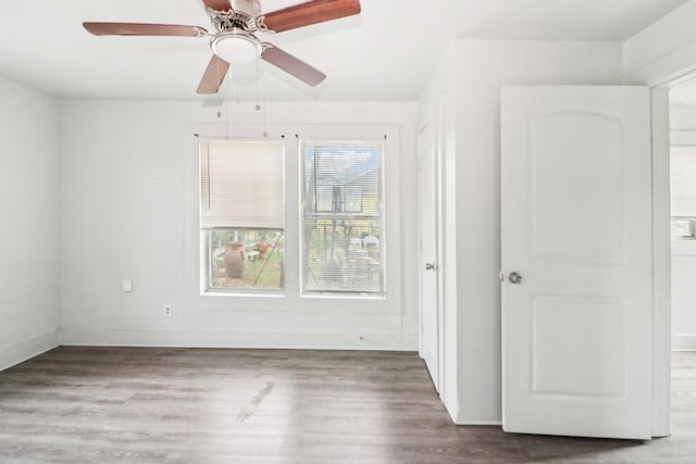 spare room featuring baseboards and wood finished floors