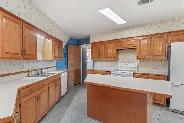 kitchen featuring light tile patterned floors, white appliances, a center island, and sink