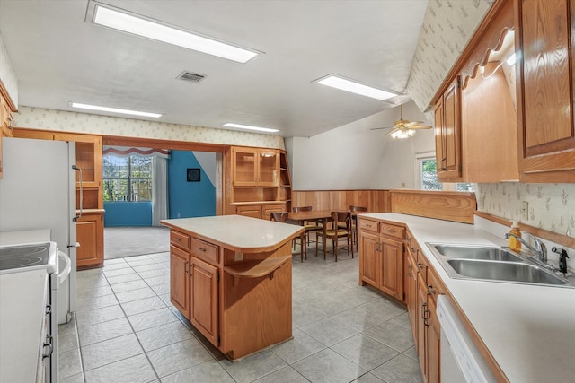 kitchen with a kitchen island, white appliances, sink, and light tile patterned floors