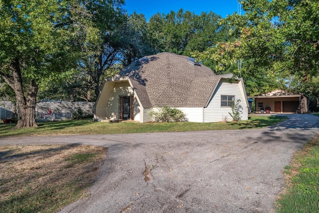 view of front of home featuring a garage, an outbuilding, and a front yard