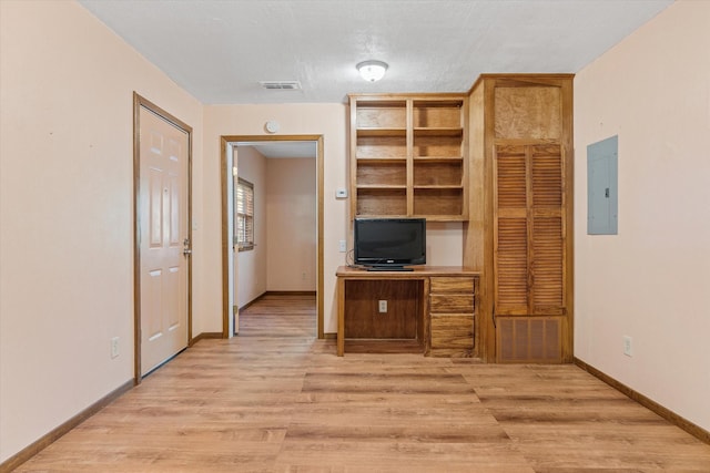 home office featuring electric panel, light hardwood / wood-style flooring, and a textured ceiling