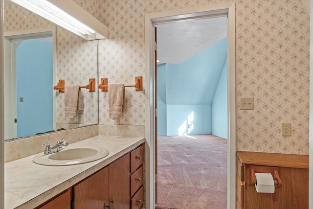 bathroom featuring vanity and vaulted ceiling with skylight