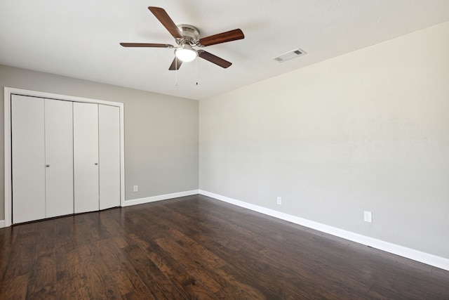 unfurnished bedroom featuring a closet, dark hardwood / wood-style floors, and ceiling fan