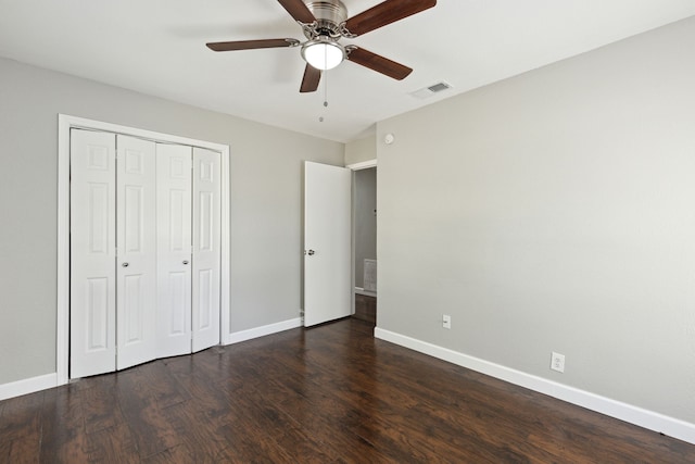 unfurnished bedroom with ceiling fan, dark hardwood / wood-style flooring, and a closet