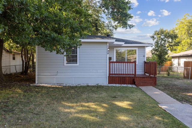 view of front of property featuring a wooden deck and a front yard