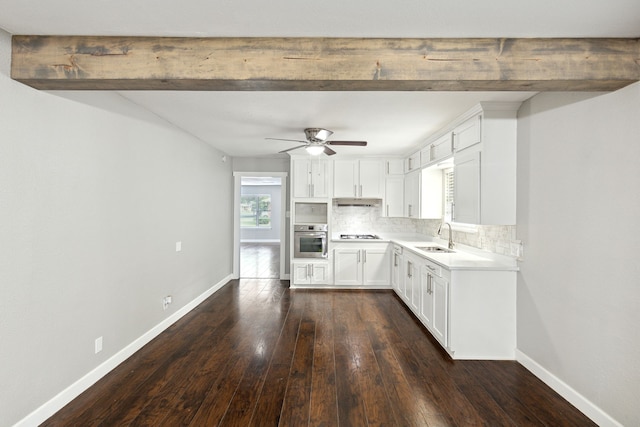 kitchen featuring gas stovetop, tasteful backsplash, dark hardwood / wood-style flooring, oven, and white cabinets