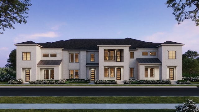 view of front of home with a standing seam roof, brick siding, and metal roof