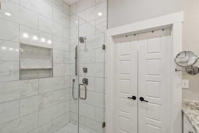 bathroom with vanity and a shower with door