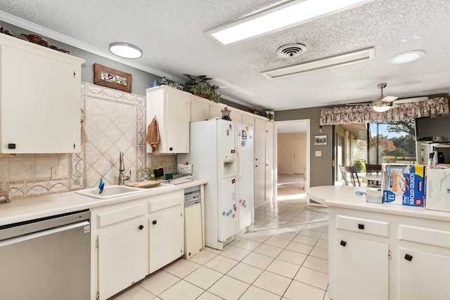 kitchen with stainless steel dishwasher, white refrigerator with ice dispenser, sink, and white cabinets