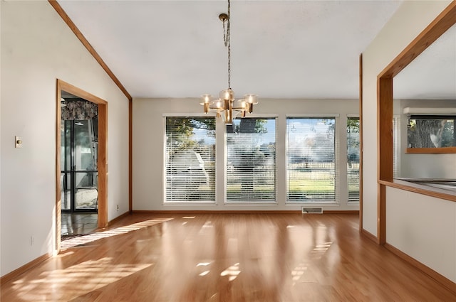 unfurnished dining area with lofted ceiling, a notable chandelier, and light hardwood / wood-style flooring