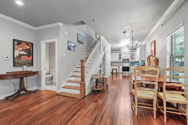 dining area with baseboards, wood finished floors, an inviting chandelier, stairs, and crown molding