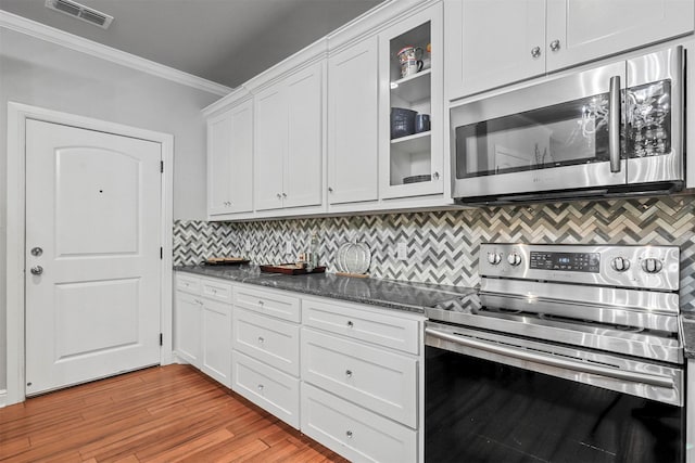 kitchen featuring white cabinets, stainless steel appliances, light wood-type flooring, and ornamental molding