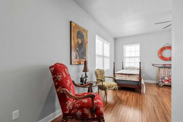 sitting room with wood-type flooring and ceiling fan