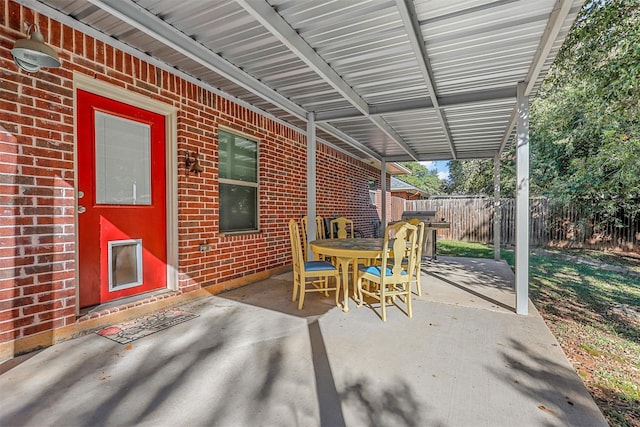 view of patio featuring a grill, fence, and outdoor dining space