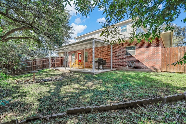 rear view of house featuring a patio area and a yard