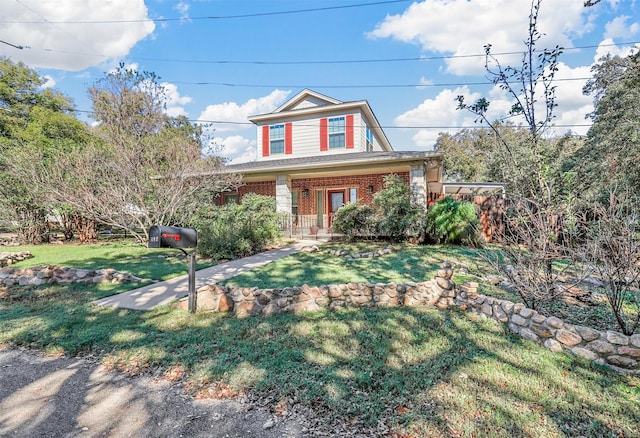 view of front of property featuring brick siding, a front lawn, and a porch