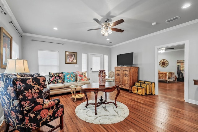 living room featuring ceiling fan, wood-type flooring, and ornamental molding