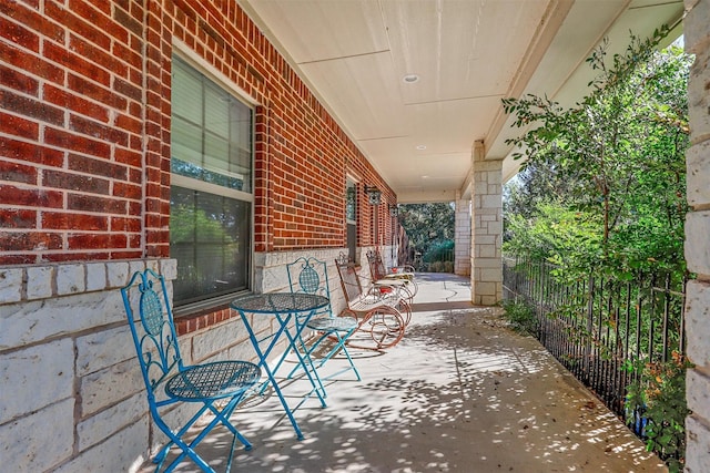 view of patio with covered porch and fence