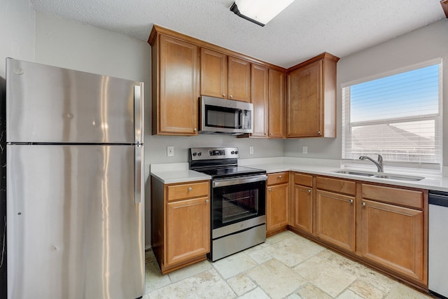 kitchen featuring appliances with stainless steel finishes, sink, and a textured ceiling