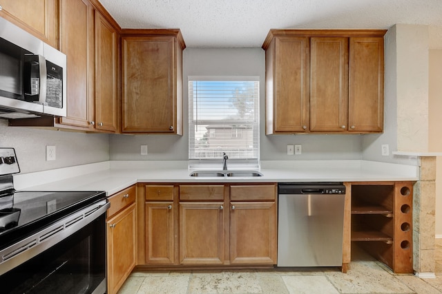 kitchen featuring stainless steel appliances, sink, and a textured ceiling