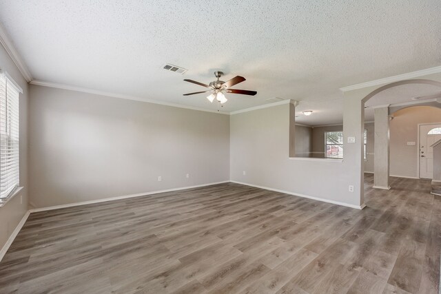 spare room featuring wood-type flooring, ceiling fan, a textured ceiling, and crown molding