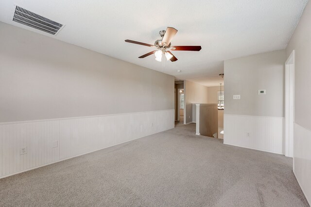 carpeted spare room featuring ceiling fan