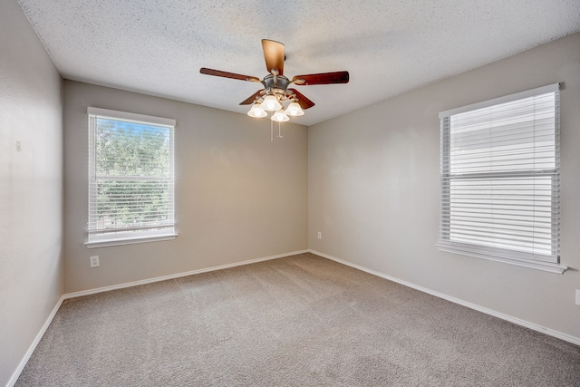 carpeted empty room with ceiling fan and a textured ceiling