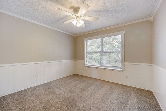 carpeted empty room with crown molding, ceiling fan, and a textured ceiling