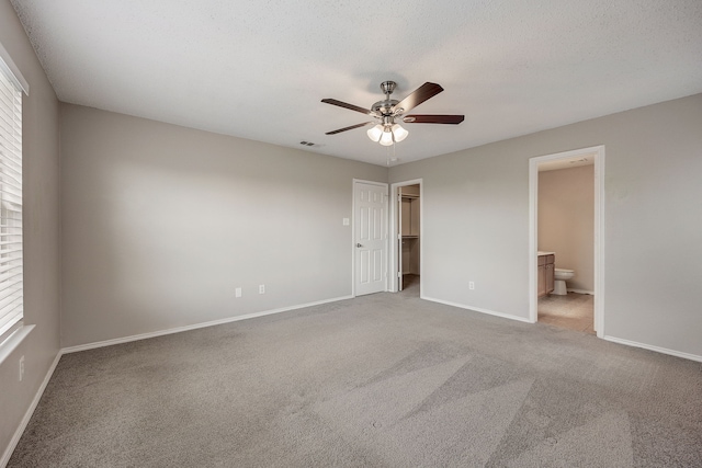 unfurnished bedroom featuring multiple windows, carpet, and a textured ceiling