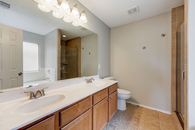 full bathroom with tile patterned floors, toilet, a textured ceiling, vanity, and independent shower and bath