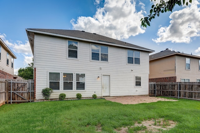 back of house with a yard and a patio