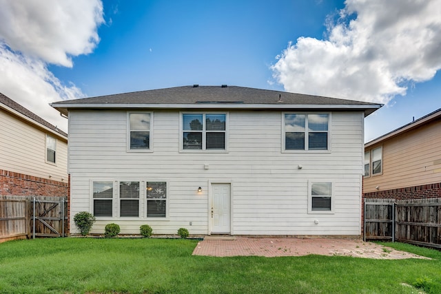 rear view of property with a yard and a patio area