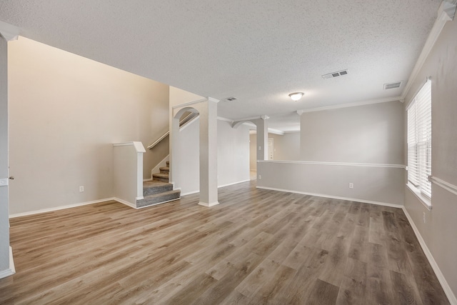 unfurnished living room with crown molding, hardwood / wood-style floors, and a textured ceiling