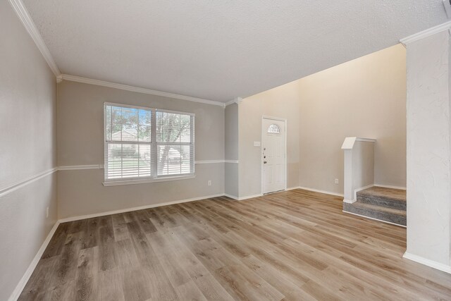 unfurnished living room with ornamental molding, a textured ceiling, and light hardwood / wood-style flooring