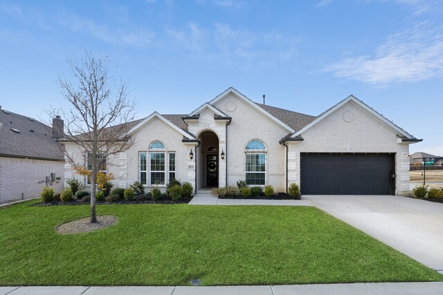 ranch-style house featuring a garage and a lawn