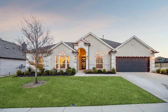 view of front of property featuring a garage and a front lawn