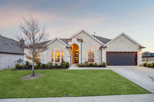 ranch-style home with a garage and a yard