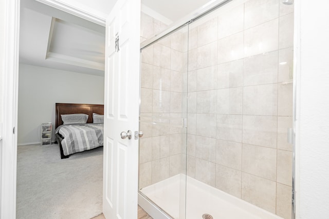 bathroom featuring a raised ceiling and an enclosed shower