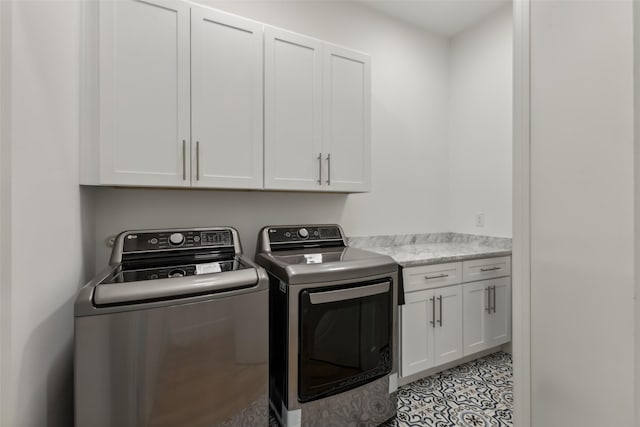 laundry area featuring separate washer and dryer and cabinets