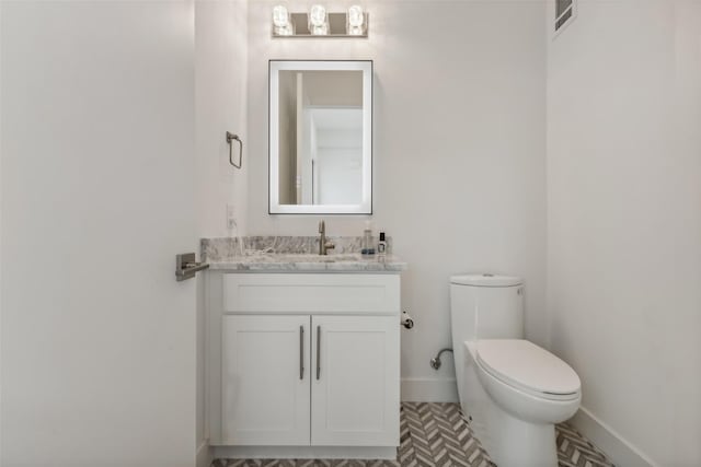 bathroom with tile patterned flooring, vanity, and toilet