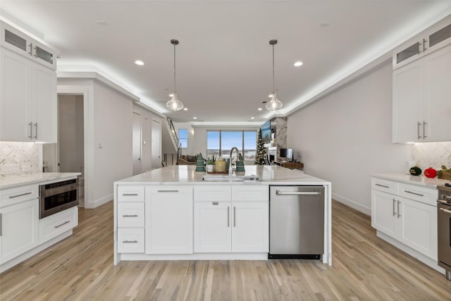 kitchen featuring a center island with sink, pendant lighting, sink, and appliances with stainless steel finishes